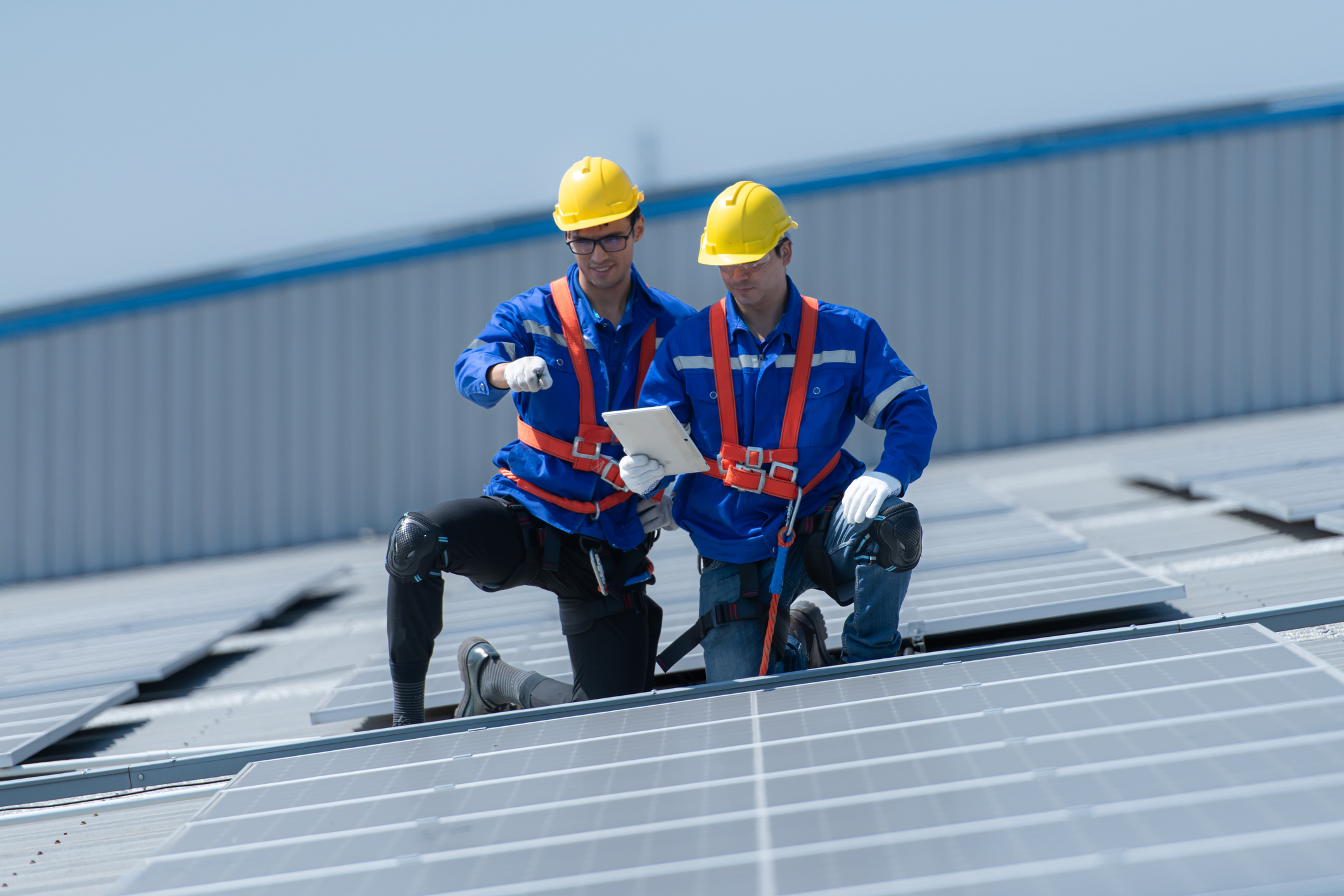 technicians is installing solar panels on the roof of the warehouse Fall protection equipment